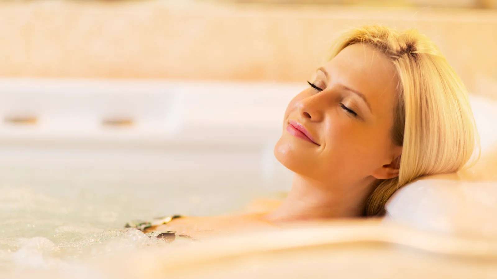 Ženska, ki se zadovoljno sprošča v jacuzziju.